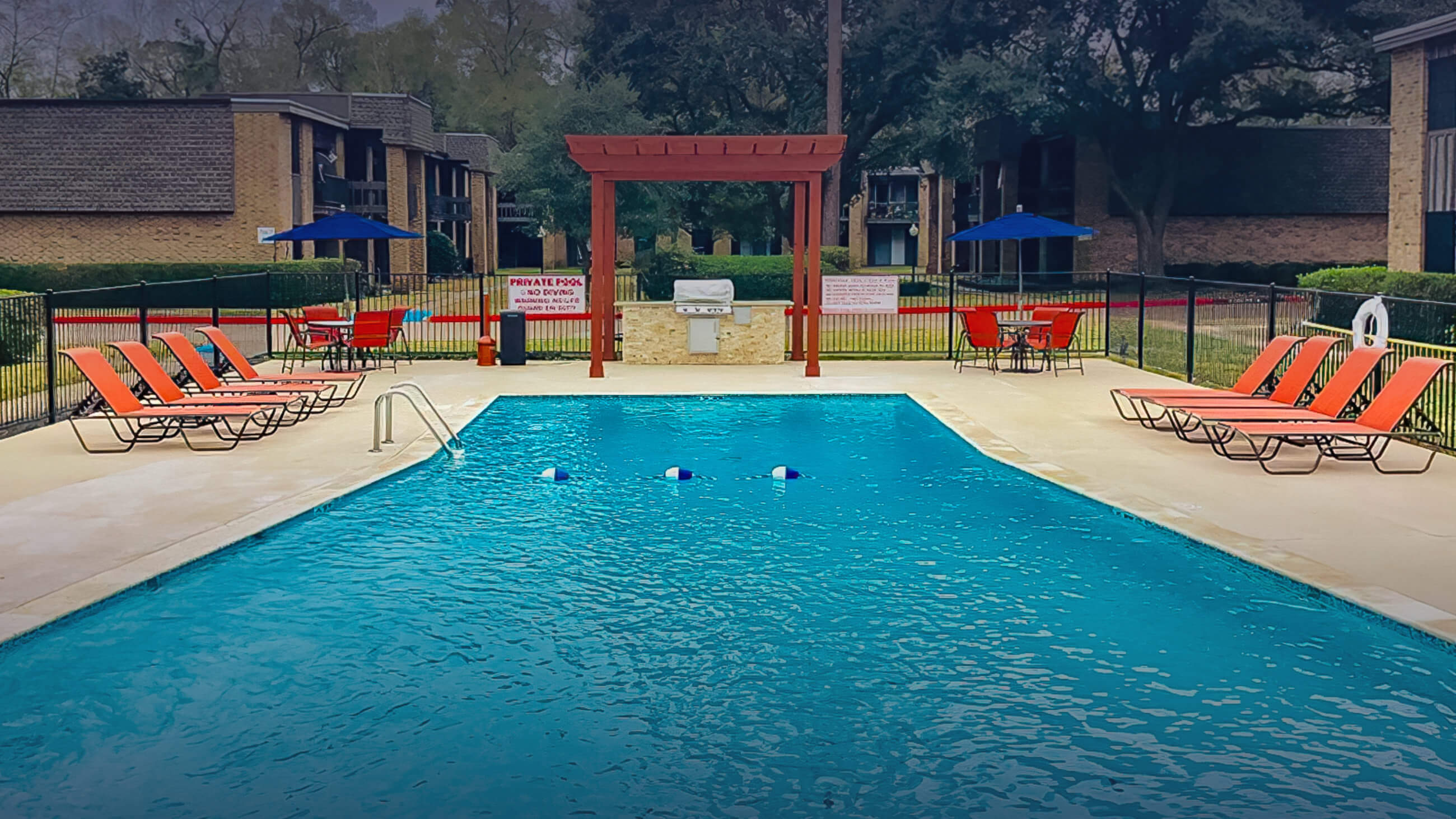 pool area with lounge chairs on both sides of the pool